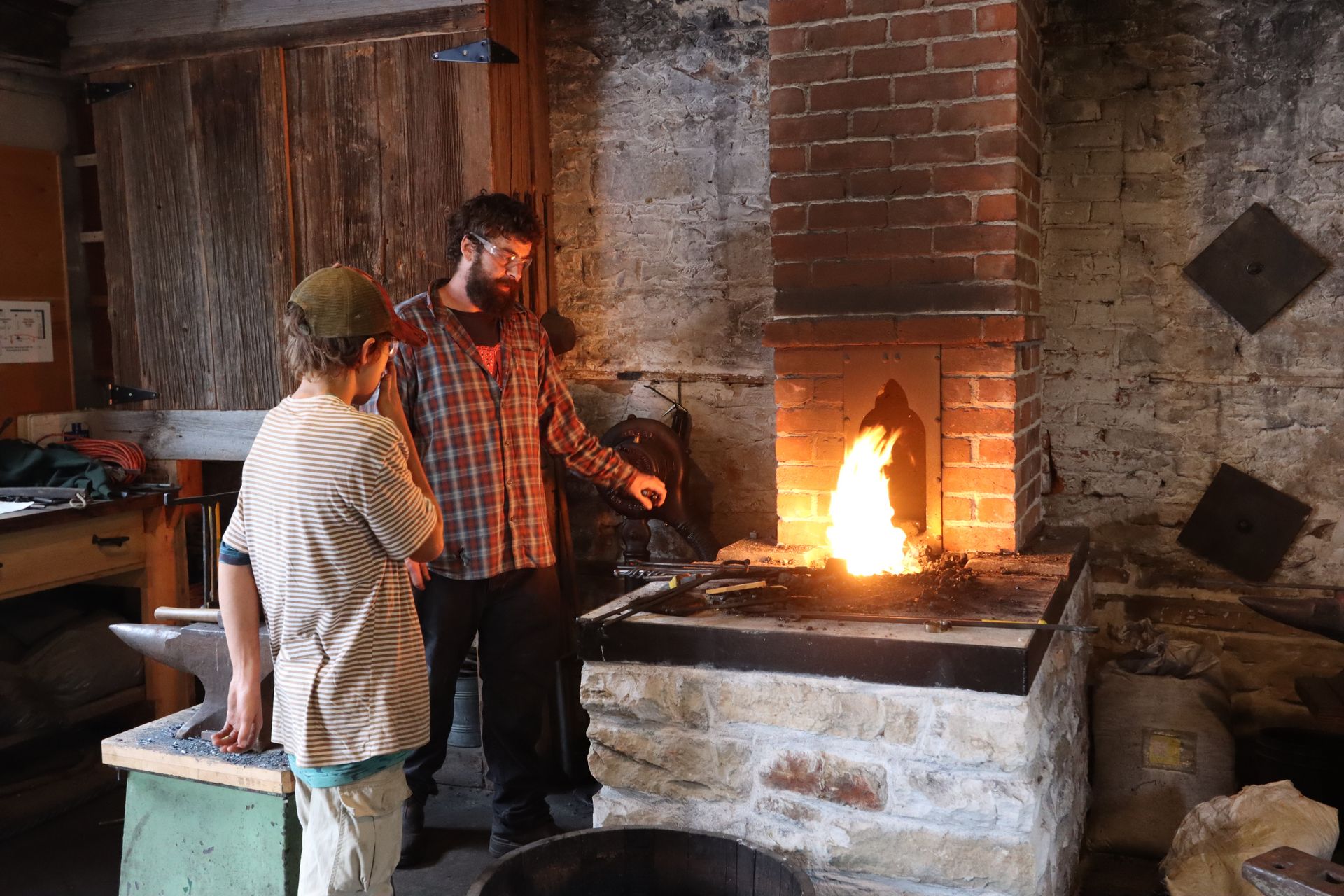 Festival visitors watching closely as the blacksmith shapes hot iron on the anvil
