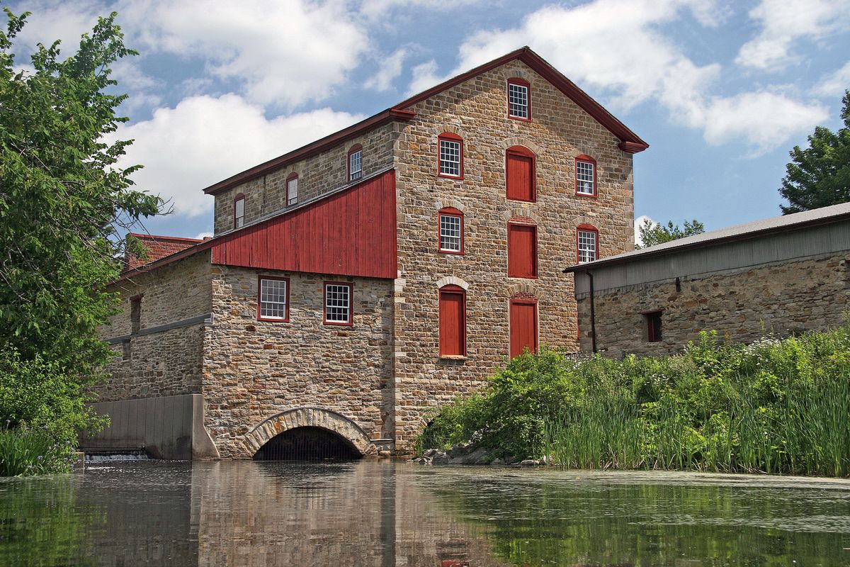 The Old Stone Mill reflected in the glassy millpond on a summer morning
