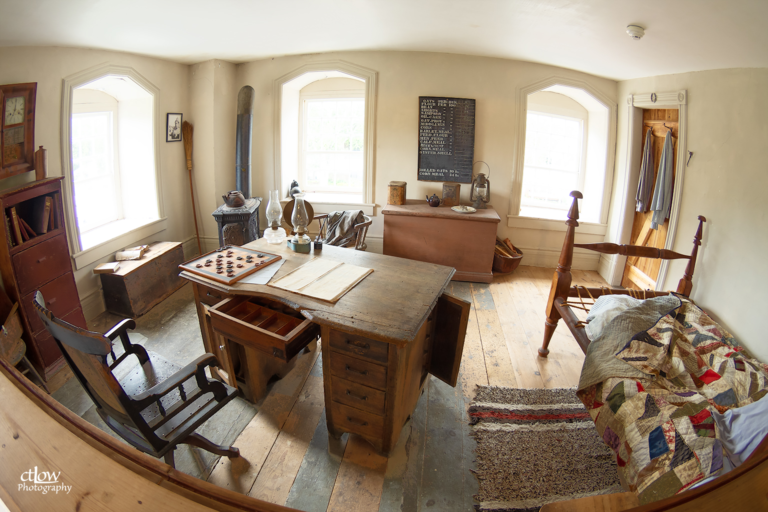 The Miller's Room inside the Old Stone Mill — desk, rocking chair, wood stove and bed furnished as in the mill's working days