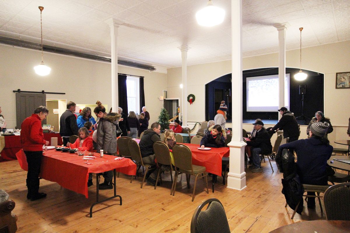 A warm festive gathering inside the Old Town Hall — lanterns, long tables, community