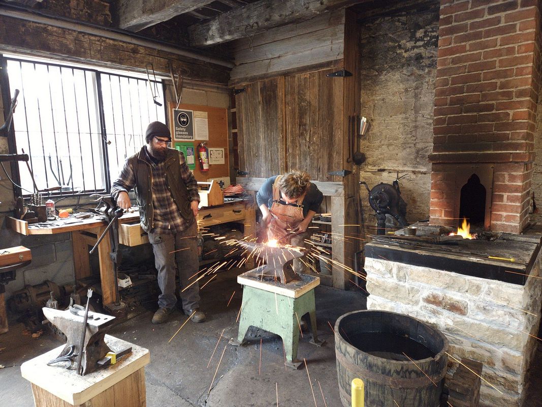 Blacksmith forge-welding — a shower of sparks over the anvil
