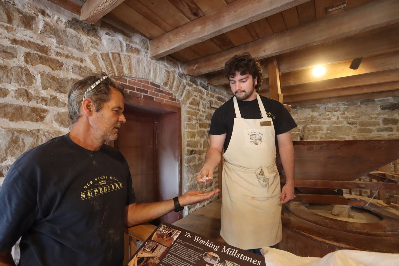 Milling demonstration — the millstones at work, grain flowing into flour